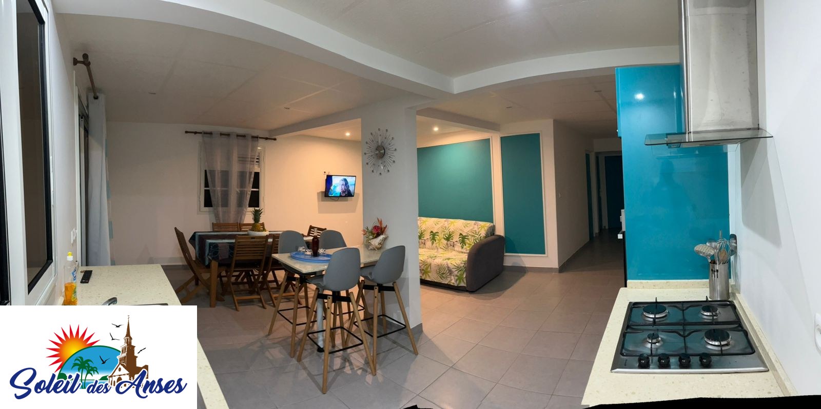 La cuisine équipée et le coin repas de l'appartement Océan, dans ses tons turquoise