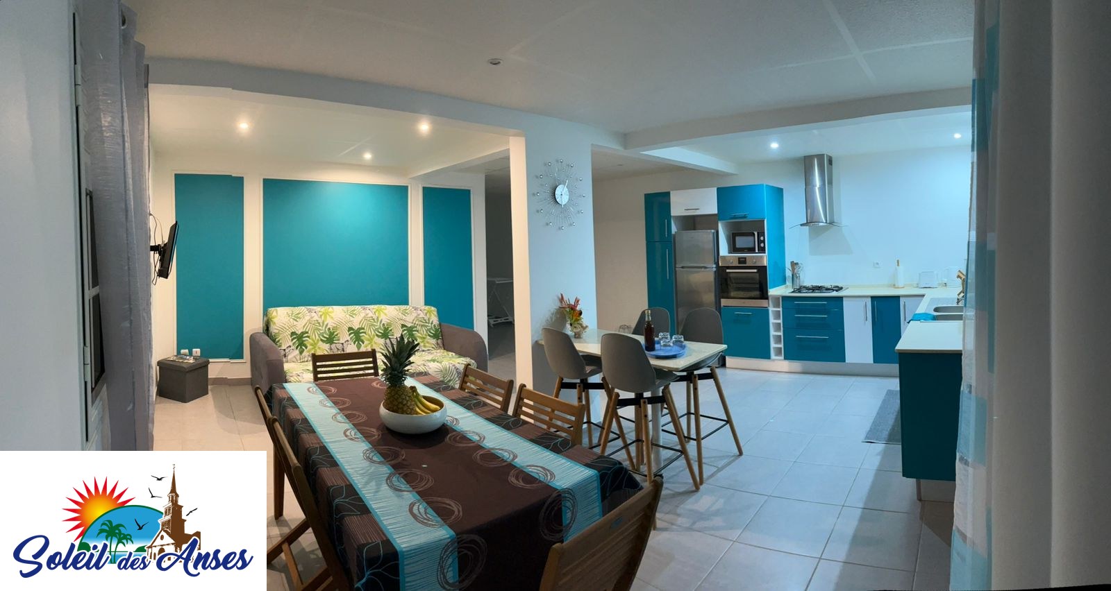 Le séjour et la cuisine ouverte de l'appartement Océan, avec la grande table et le coin repas